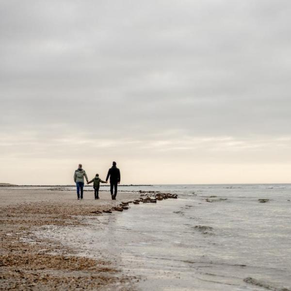 Familie på gåtur på strande i Blåvand