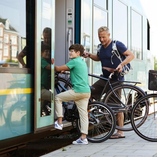 Familie på vej ind i et Arriva tog med cykler