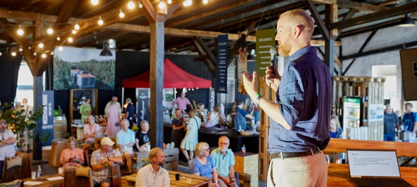 Mand står og taler foran publikun