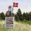 Skilt med en viking på, som holder et Danmarks flag