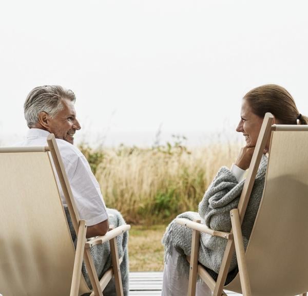 Par hygger sig i strandstole ved vandet