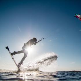 Mand kitesurfer over fjorden